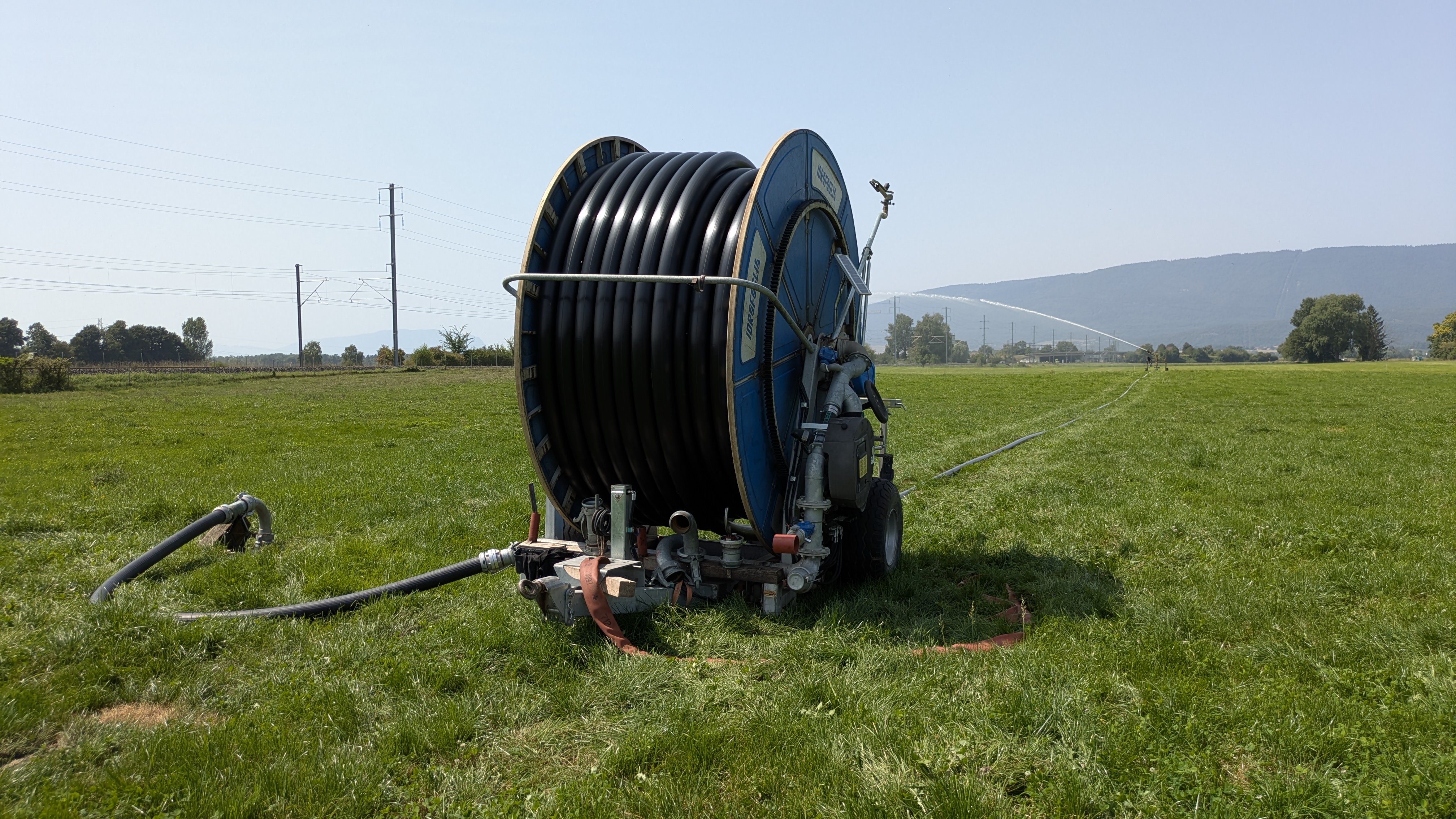 Automatischer Schlauchhaspel, der angetrieben durch den Wasserfluss den Schlauch langsam aufrollt und den Regnerwagen über die Wiese zieht. Haspel